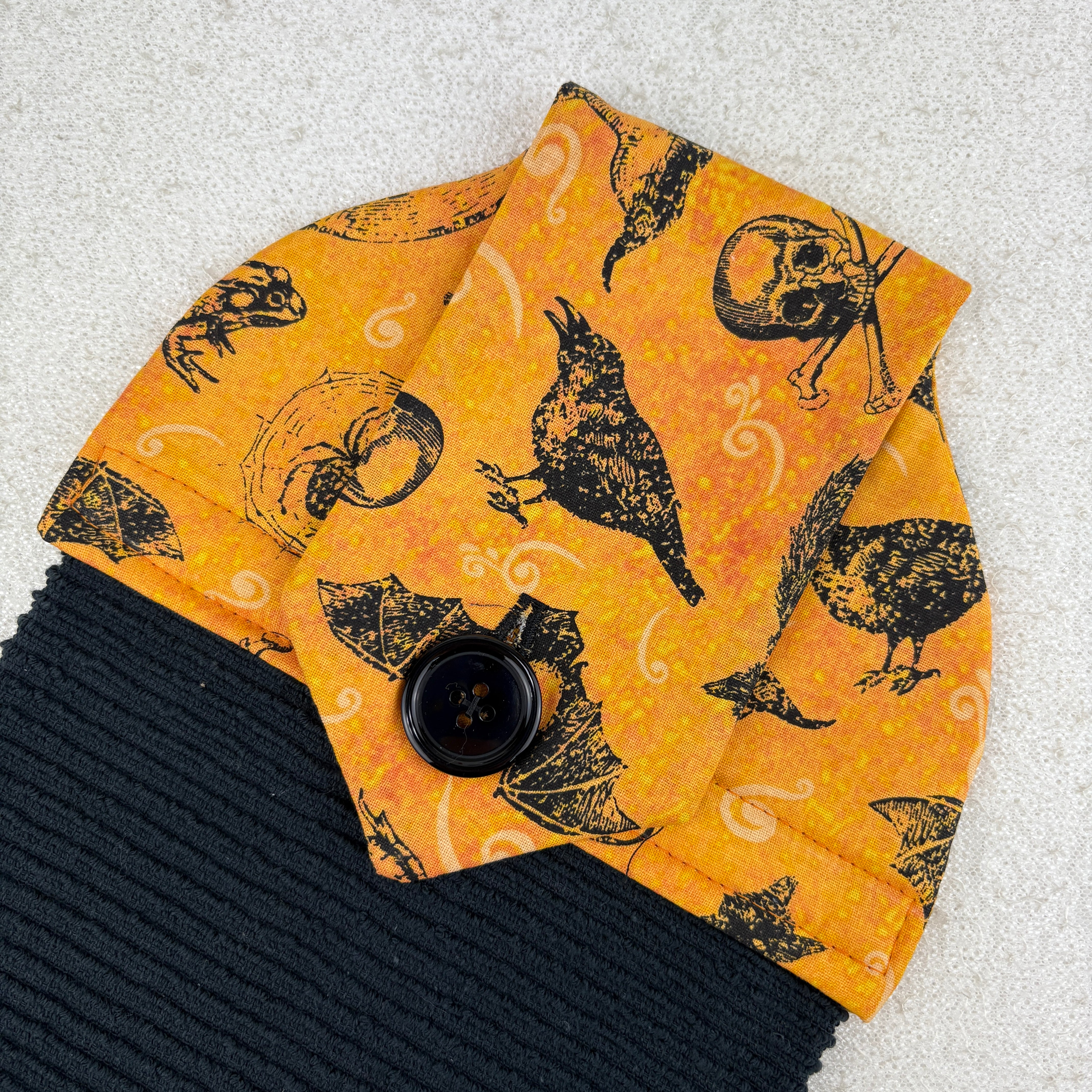 kitchen towel with skulls, crows, witch hats, bats and frogs