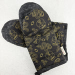 Load image into Gallery viewer, Black oven mitt with gold skull and snake pattern on a white background
